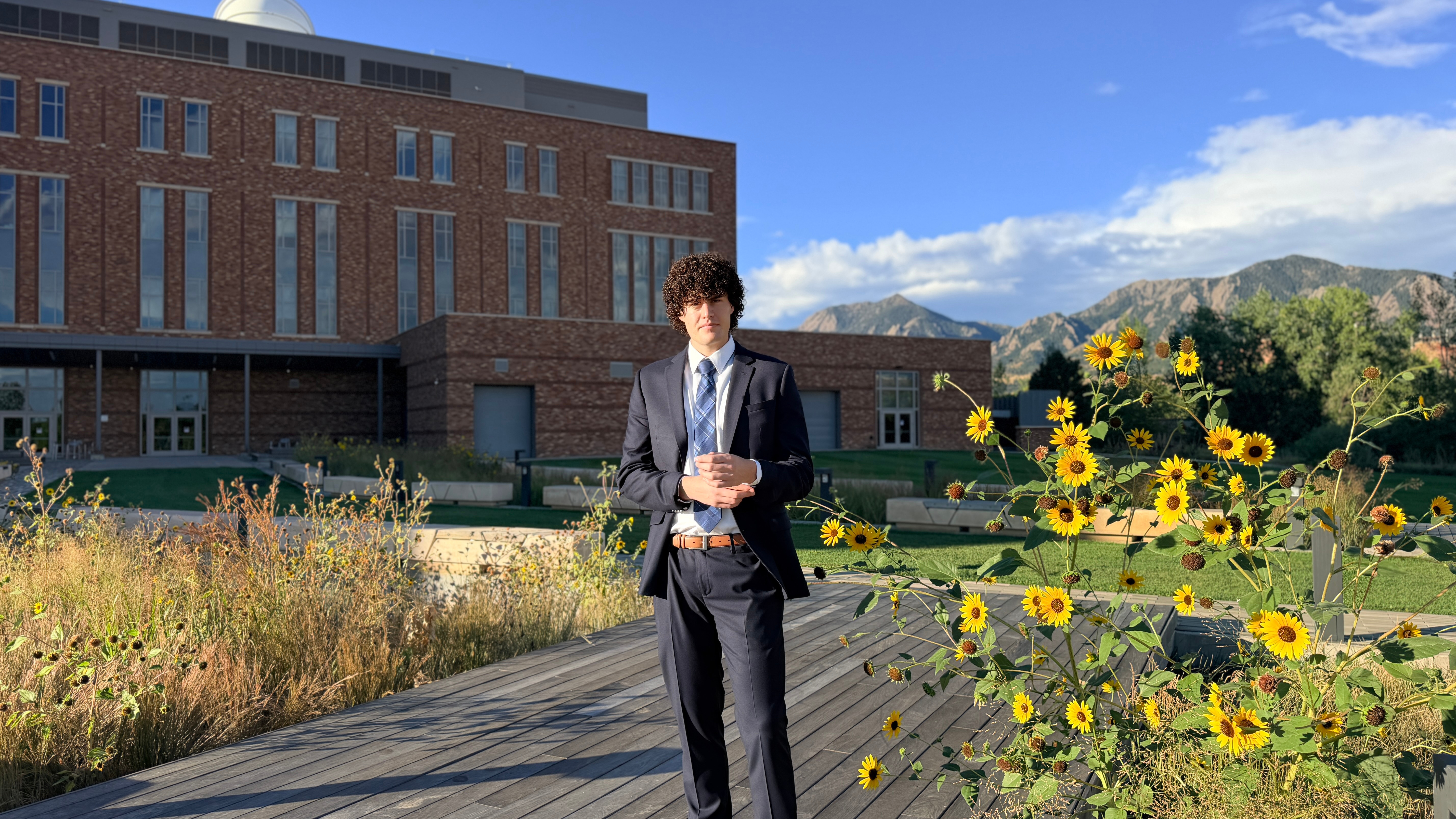 Ryan Cross beside flowers with the Flatirons in the background
