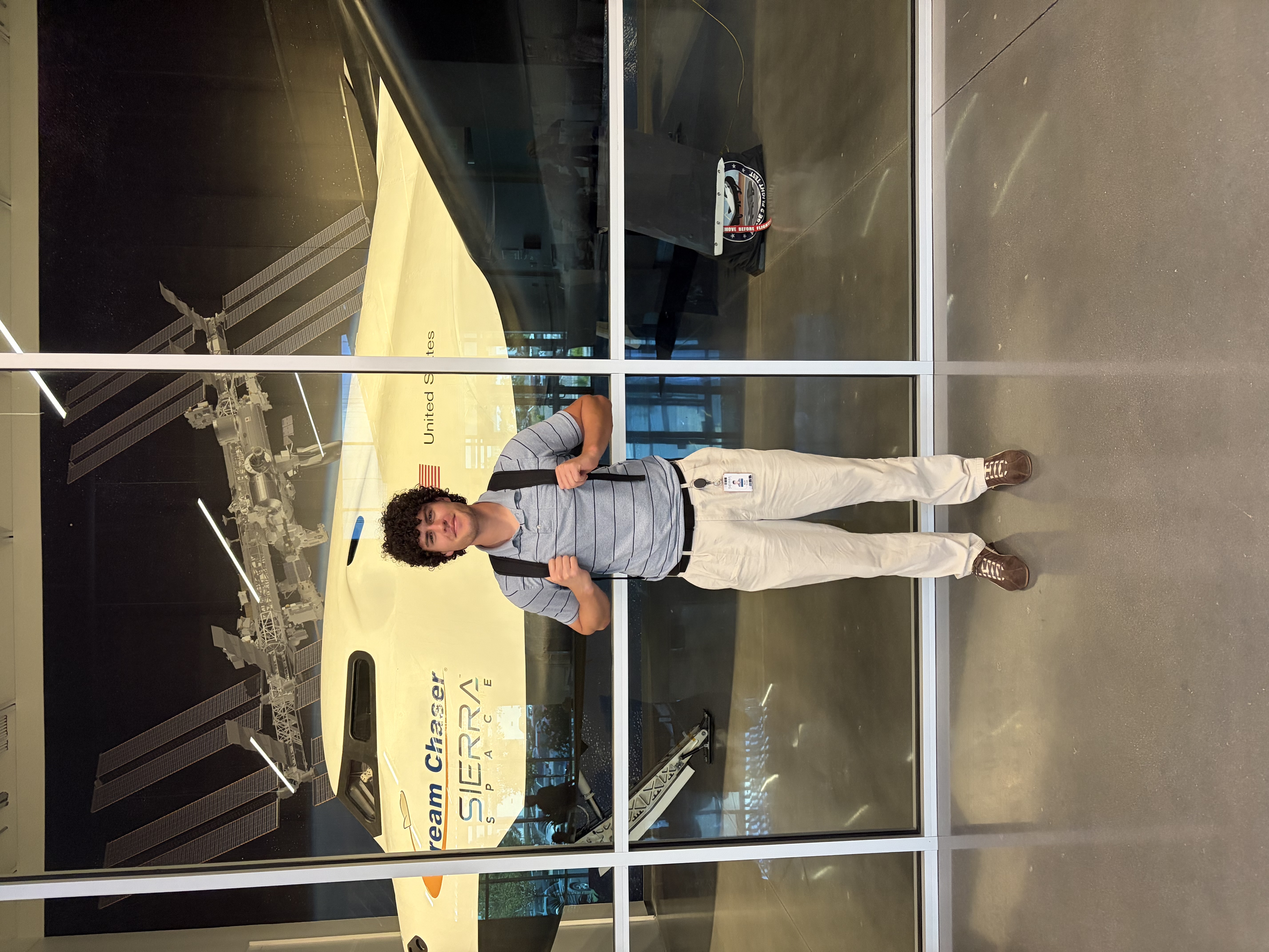 Ryan Cross standing in front of Sierra Space's Dream Chaser spacecraft